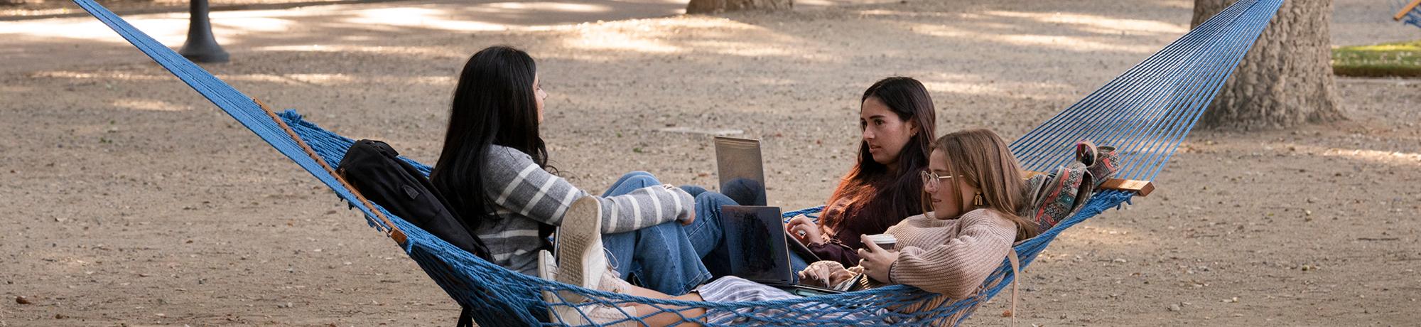 Three students enjoying a hammock together